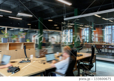 Modern office space with employees working in a collaborative environment during daytime hours 133600675