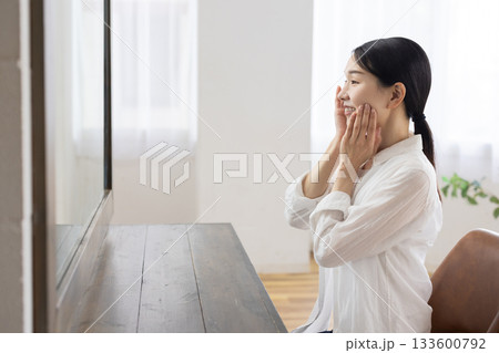 鏡に映る自分の顔を見て微笑むミドル女性 133600792