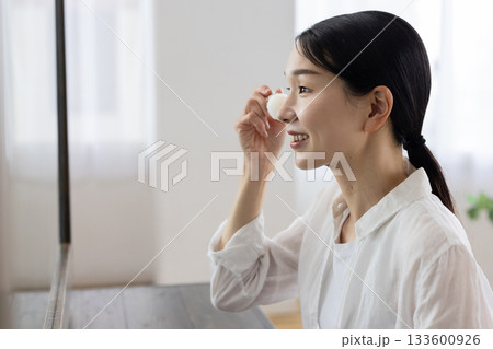 鏡を見ながらメイクするミドル女性 133600926