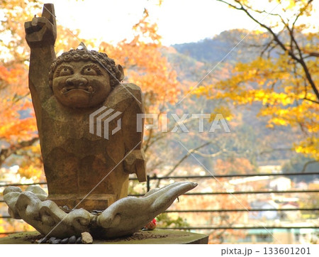 鬼怒川温泉の紅葉を背に空を指差す鬼怒太像 133601201