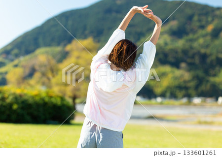 屋外でストレッチ体操をするミドル女性 133601261