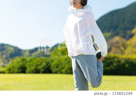 屋外でストレッチ体操をするミドル女性 屋外でストレッチ体操をするミドル女性 133601294