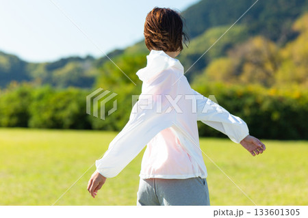 屋外でストレッチ体操をするミドル女性 屋外でストレッチ体操をするミドル女性 133601305