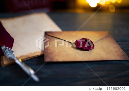Blank Brown Paper Page on Black Wood Table with Christmas Decoration. Mock Up of Letter to Santa Claus. Top View of Jolly Father Desk with Envelopes, Xmas Ornament. View from Above. 133602001
