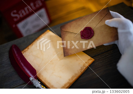 Close up of Santa Claus hands writing letter on Worden desk with copy space 133602005