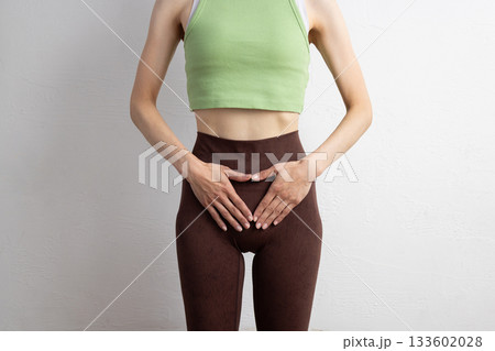 骨盤の位置を示すスポーツウェア姿の女性のクローズアップ 133602028