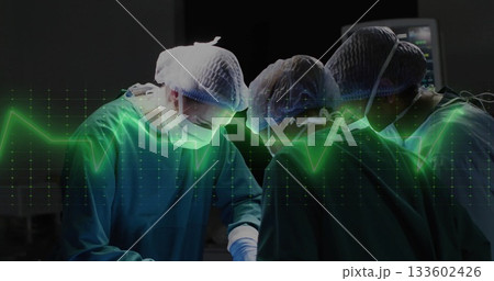 Performing surgery three surgeons wearing gowns leaning over patient in OR, with ECG waveform 133602426