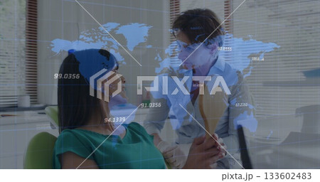 Dentist in lab coat inspecting patient's mouth at dental clinic, with mirror and world map overlay 133602483