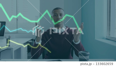 Gesturing male professional analyzing holographic line charts at office with laptop and coffee cup Gesturing male professional analyzing holographic line charts at office with laptop and coffee cup 133602659