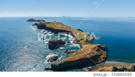 Wide drone panorama of Ponta de Sao Lourenco peninsula Madeira, bright postcard colors reveal green grass lava cliffs and azure Atlantic water in cinematic seascape Wide drone panorama of Ponta de Sao Lourenco peninsula Madeira, bright postcard colors reveal green grass lava cliffs and azure Atlantic water in cinematic seascape 133603288