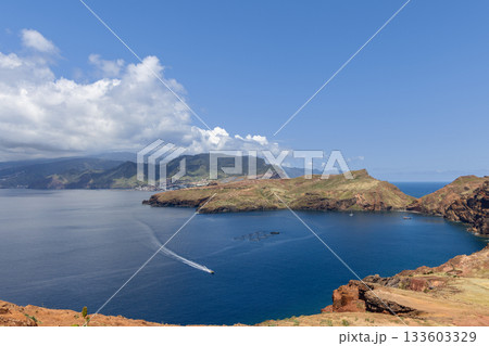 Sao Lourenco Madeira coast with boat wake bright blue bay and green mountains in distance Sao Lourenco Madeira coast with boat wake bright blue bay and green mountains in distance 133603329