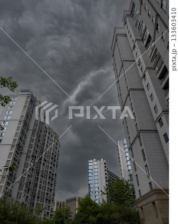 Tall residential buildings under a dramatic cloudy sky during daytime in China 133603410