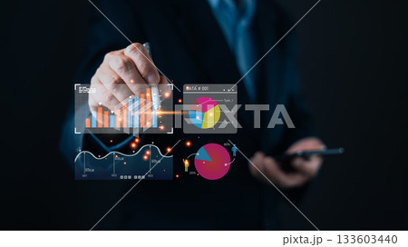 A business professional interacts with a digital interface displaying charts, graphs, and data visualizations, symbolizing digital insights, marketing strategies, and dashboard tools for the analyst. A business professional interacts with a digital interface displaying charts, graphs, and data visualizations, symbolizing digital insights, marketing strategies, and dashboard tools for the analyst. 133603440