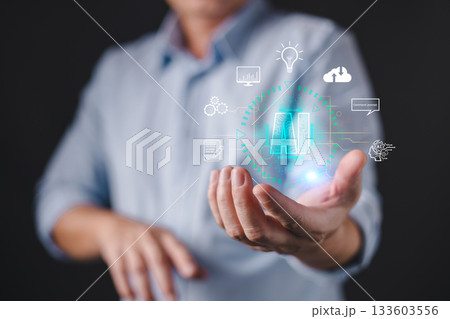 A person presents a glowing holographic interface featuring the letters AI surrounded by icons representing innovation, data, cloud, command, and technology, artificial intelligence concepts. A person presents a glowing holographic interface featuring the letters AI surrounded by icons representing innovation, data, cloud, command, and technology, artificial intelligence concepts. 133603556