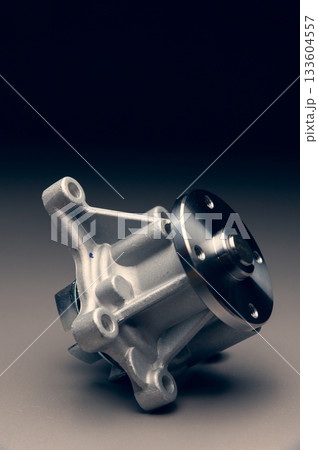 Engine cooling pump, engine coolant pump for a passenger car on a black gradient background. Selective focus Engine cooling pump, engine coolant pump for a passenger car on a black gradient background. Selective focus 133604557