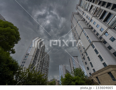 Tall residential buildings under a dramatic cloudy sky during daytime in China Tall residential buildings under a dramatic cloudy sky during daytime in China 133604665