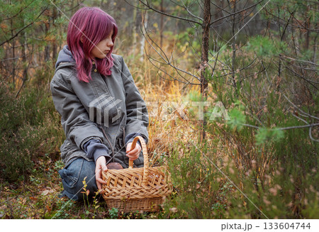 Young girl mushroom picking in autumn forest 133604744