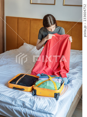 Woman packing clothes for travel trip preparing suitcase Woman packing clothes for travel trip preparing suitcase 133604752