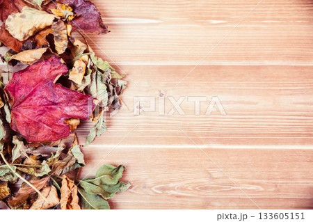 Overhead view of dry leaves on wooden table 133605151