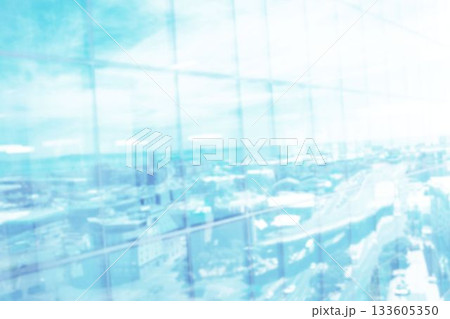 Defocussed image of modern cityscape and blue sky reflected in glass building front, with copy space 133605350