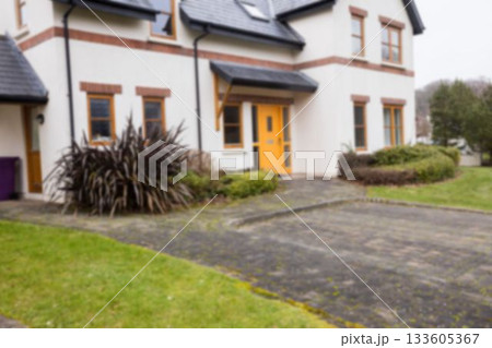 Facade of white house with driveway 133605367