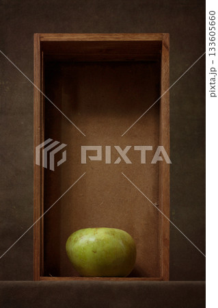 Still life with a green apple in a wooden box 133605660