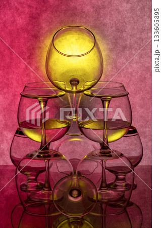Still life with glassware with liquid on colored background Still life with glassware with liquid on colored background 133605895