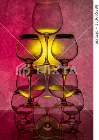 Still life with glassware with liquid on colored background Still life with glassware with liquid on colored background 133605898