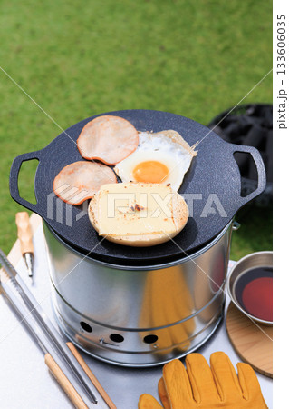 黒いマルチグリドルと具材のクローズアップ、芝生の緑を背景に 133606035