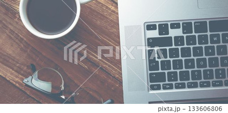High angle view of laptop with coffee cup on table High angle view of laptop with coffee cup on table 133606806