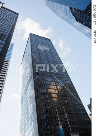 dark-glass grid office tower is standing in flat design scene with street-lamp and parking sign 133606972
