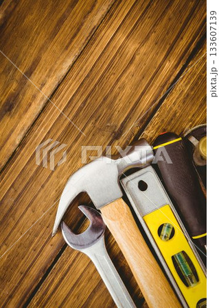 showing flat design hammer, wrench, spirit level, screwdriver, tape measure resting on wooden plank 133607139