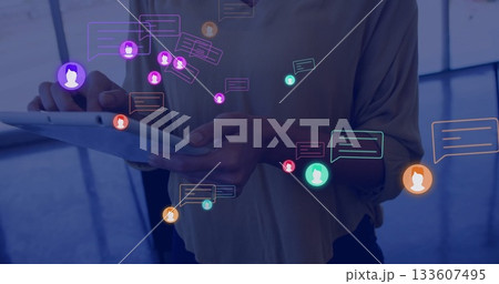 Woman in professional attire scanning digital icons on tablet in office lobby, digital theme 133607495