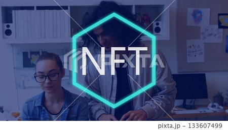 Collaborating colleagues examining screen at modern office desk, with turquoise NFT hexagon overlay 133607499
