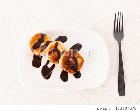 Curd fritters with chocolate on the porcelain plate. 133607979