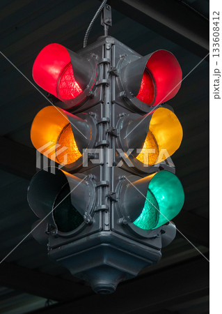 Traffic light under the bridge with red, yellow and green colors. Safety regulations. Traffic light in the city closeup Traffic light under the bridge with red, yellow and green colors. Safety regulations. Traffic light in the city closeup 133608412