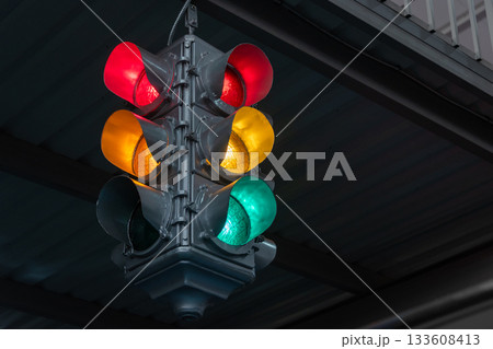 Traffic light under the bridge with red, yellow and green colors. Safety regulations. Traffic light in the city closeup 133608413