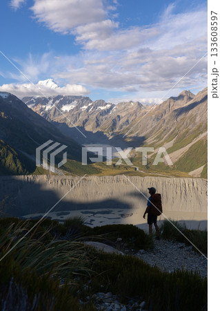 Hiker overlooking glacial Hooker Lake and Mount Cook, New Zealand Hiker overlooking glacial Hooker Lake and Mount Cook, New Zealand 133608597
