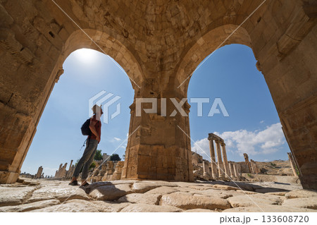 Tourist admiring ancient North Tetrapylon arch in Jerash ruins, Jordan 133608720
