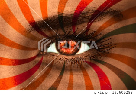 Orange eye on patterned face Orange eye on patterned face 133609288