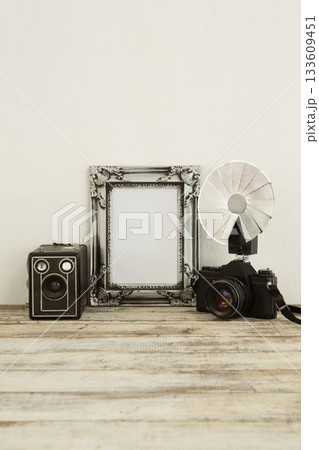 Photo frame, speaker and camera on table 133609451