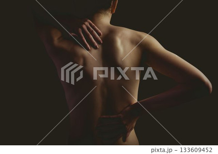 Woman is showing bare back in flat design, with dark backdrop and soft lighting emphasizing curves 133609452