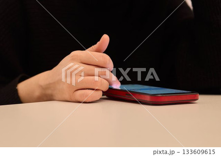 Nightly hand gestures on smartphone, Fingers tapping and engaging with phone during night hours, Closeup shot capturing hand movements interacting with mobile device at night Nightly hand gestures on smartphone, Fingers tapping and engaging with phone during night hours, Closeup shot capturing hand movements interacting with mobile device at night 133609615