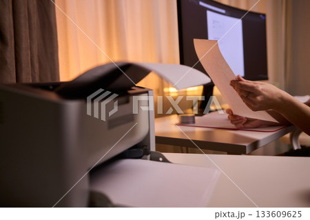 Closeup of professional reviewing agreement documents diligently, Dedicated editor engaged in thorough review and precise marking of legal documentation during late working hours 133609625