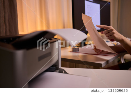 Closeup of professional reviewing agreement documents diligently, Dedicated editor engaged in thorough review and precise marking of legal documentation during late working hours 133609626