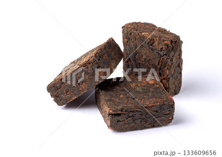 Three pieces of pressed fermented black tea isolated on white background. 133609656