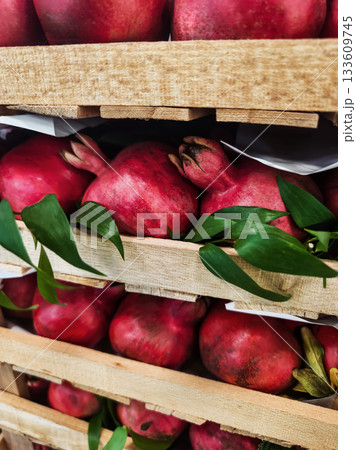 Fresh pomegranates stacked in wooden crates at a local market in autumn season 133609745