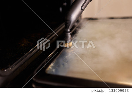 Steam tool purges baked grease, Focused steam device eliminates stubborn oven grime, Precise steam cleaning process handles tough residue from oven glass door effectively 133609938