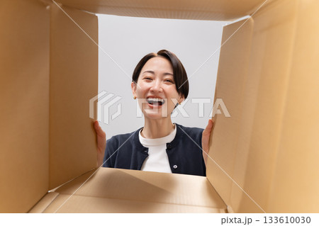 ダンボールを覗く女性　笑顔 133610030