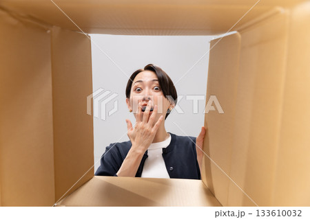 ダンボールを覗く女性　驚く 133610032